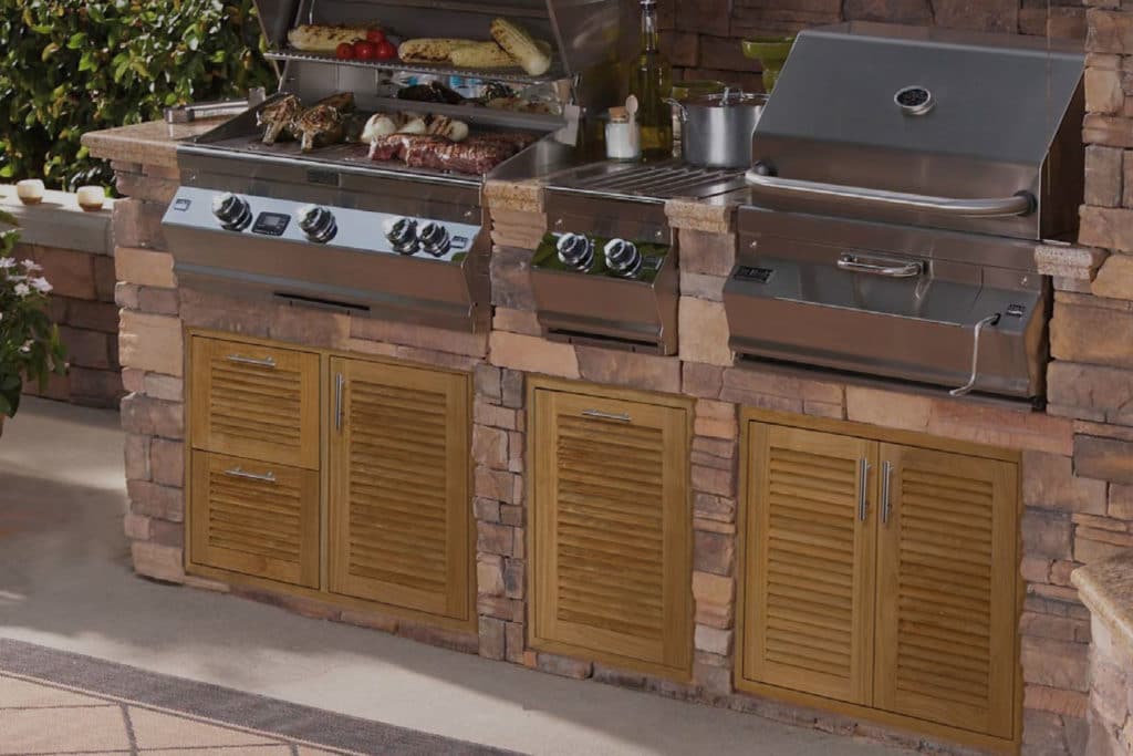 Built-in grills above louvered teak cabinet doors in a stone island